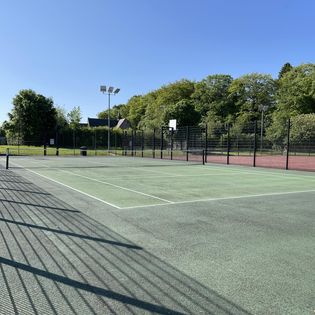 A picture of the Symington Spark MUGA tennis court, empty on a sunny day.